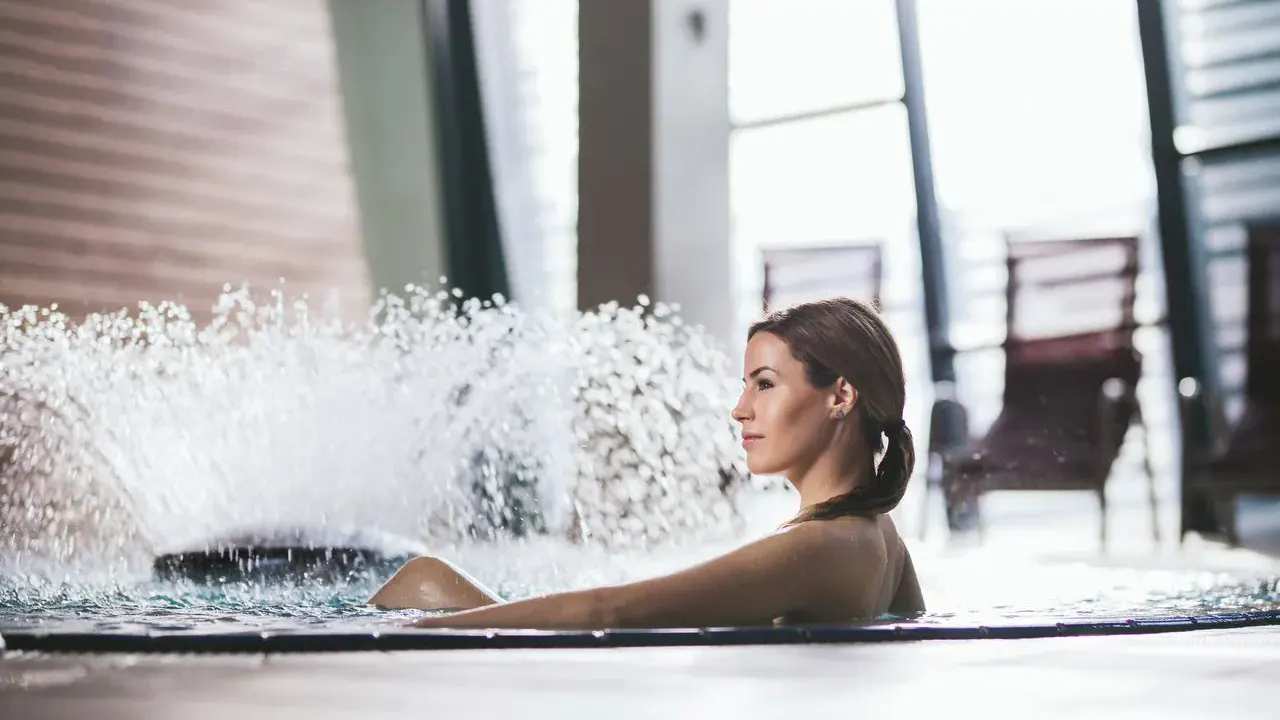 Eine Dame im Pool mit Springbrunnen imn der Terme Vivat