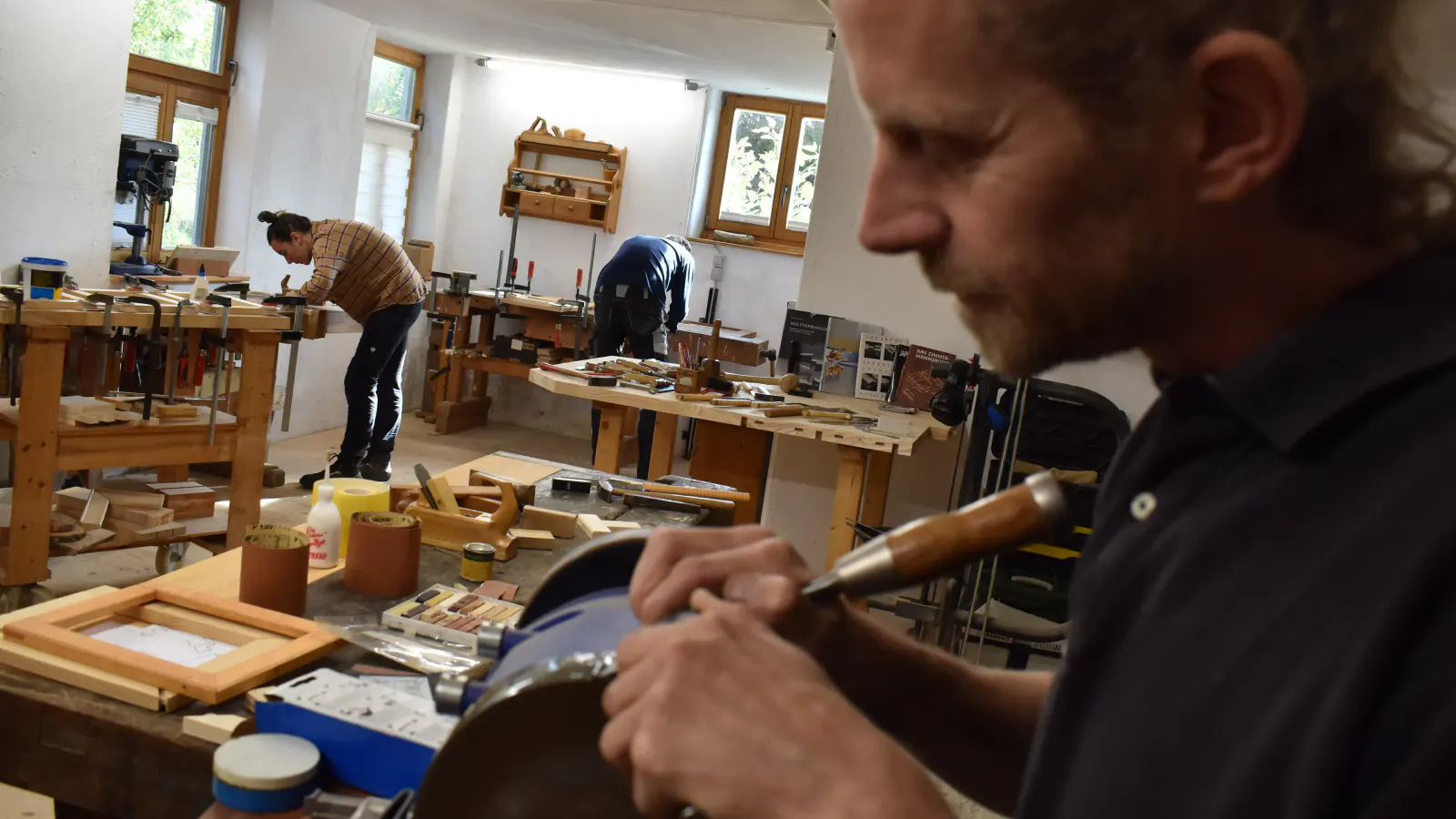 Holzatelier mit Thomas Hitzenhammer und Kursteilnehmenden im Hintergrund