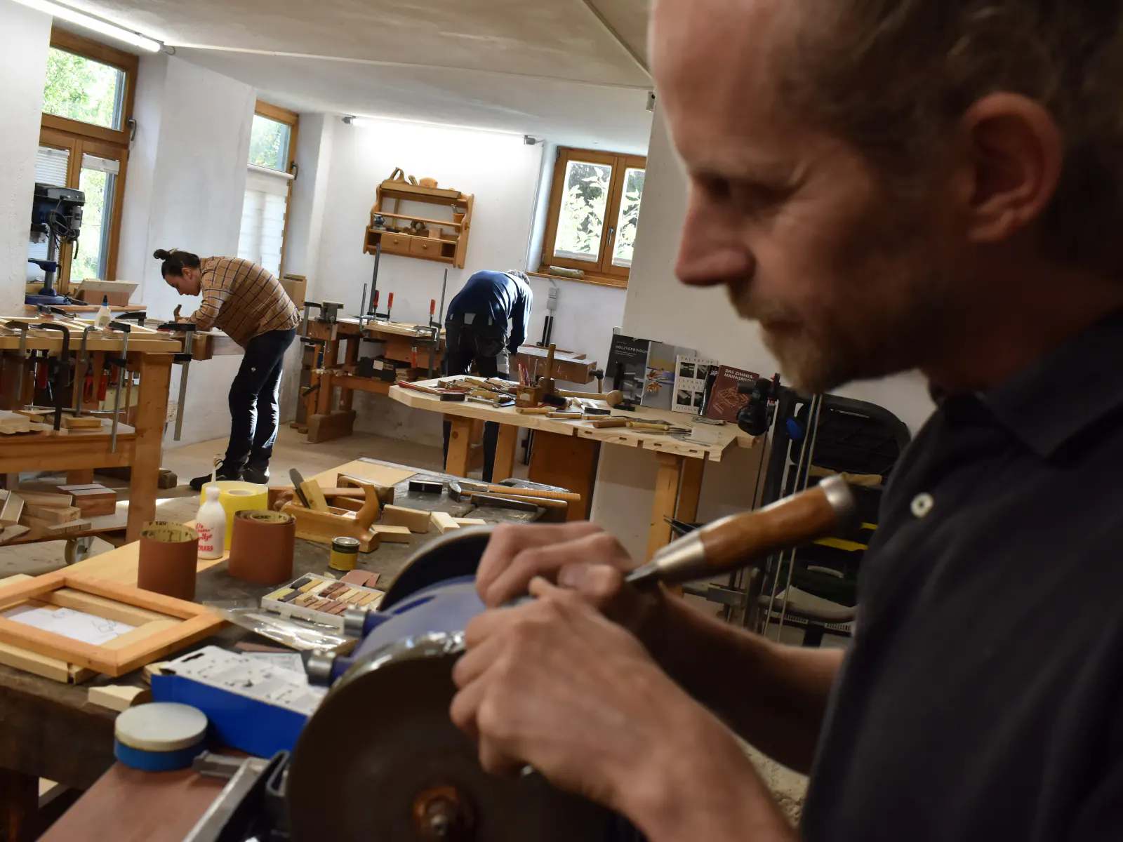Holzatelier mit Thomas Hitzenhammer und Kursteilnehmenden im Hintergrund