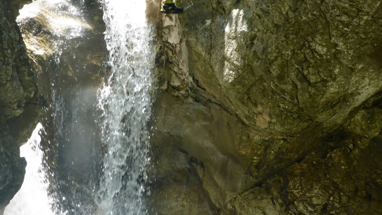 Eine Person springt einen großen Wasserfall hinunter.