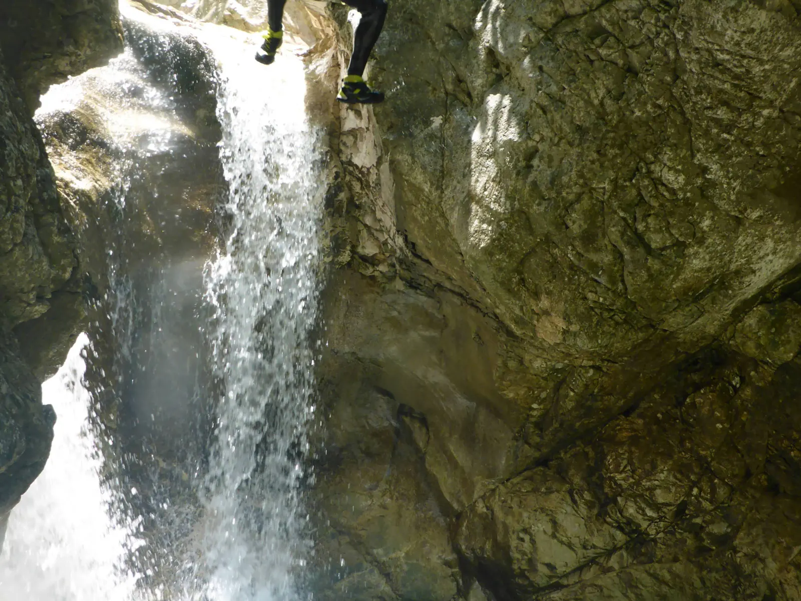 Eine Person springt einen großen Wasserfall hinunter.
