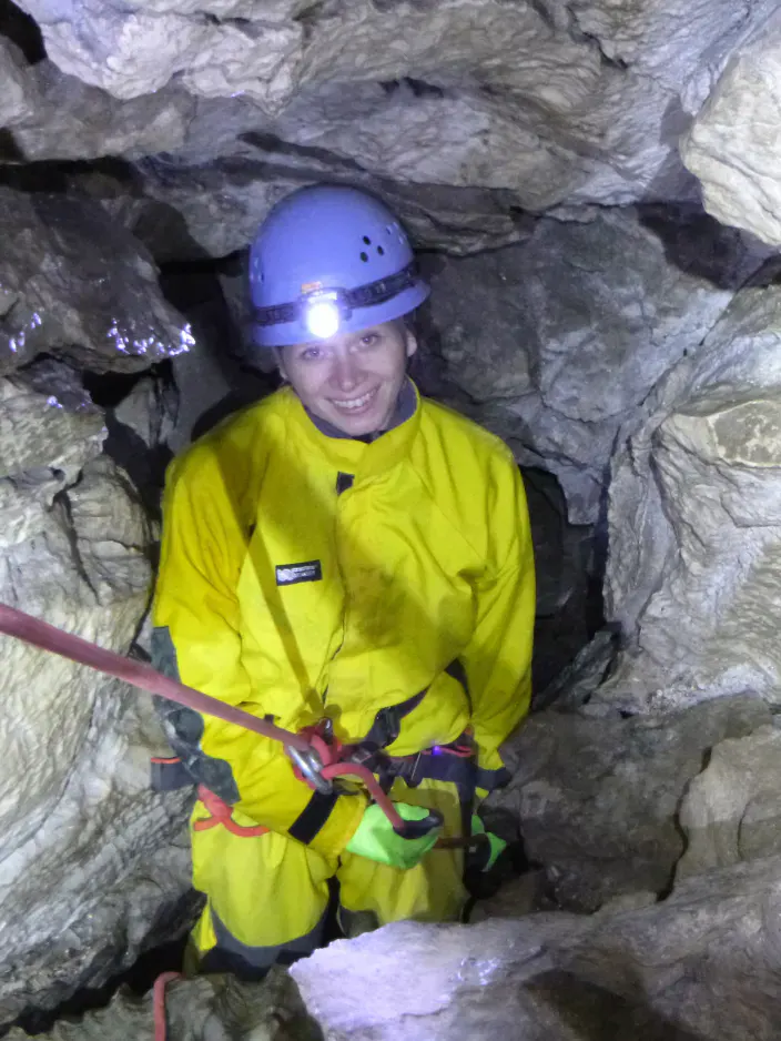Eine Frau seilt sich in der Höhle ab.