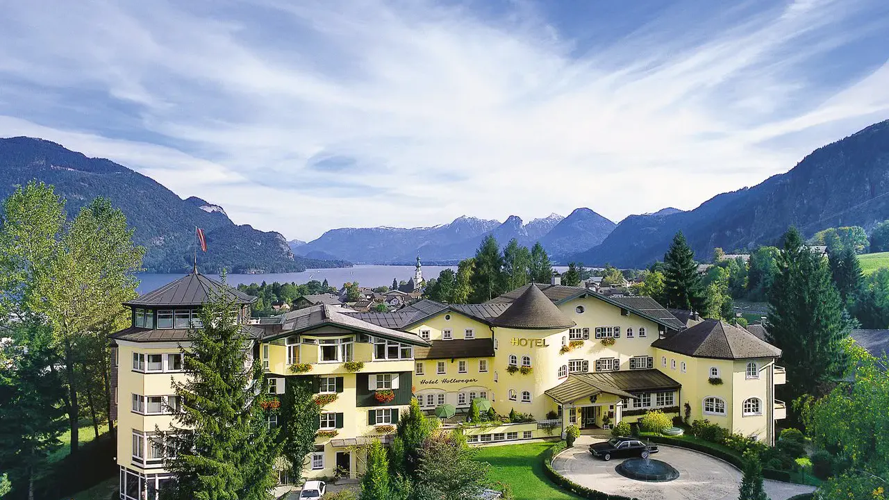 Aussenansicht des Hotels Hollweger mit Wolfgangsee und Bergen im Hintergrund