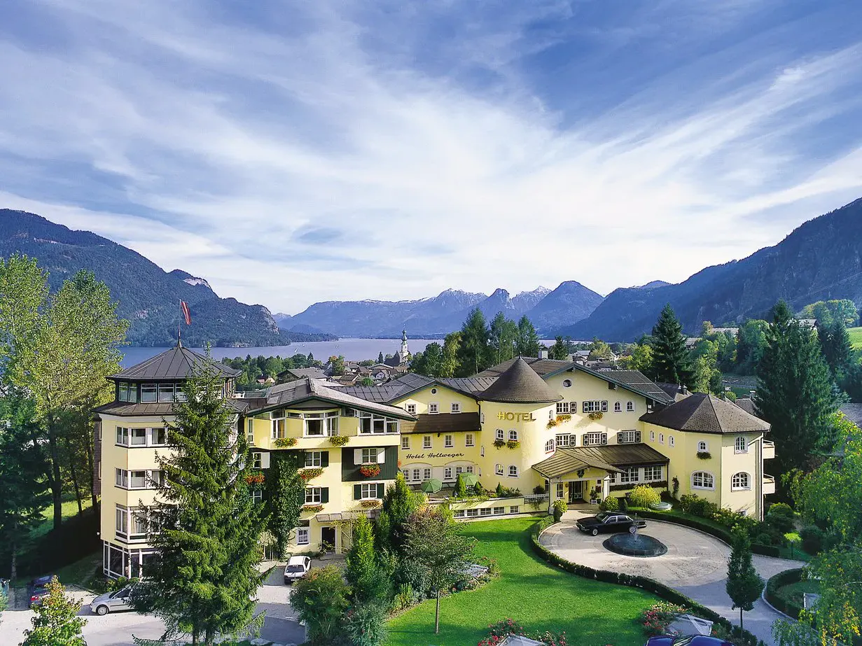 Aussenansicht des Hotels Hollweger mit Wolfgangsee und Bergen im Hintergrund