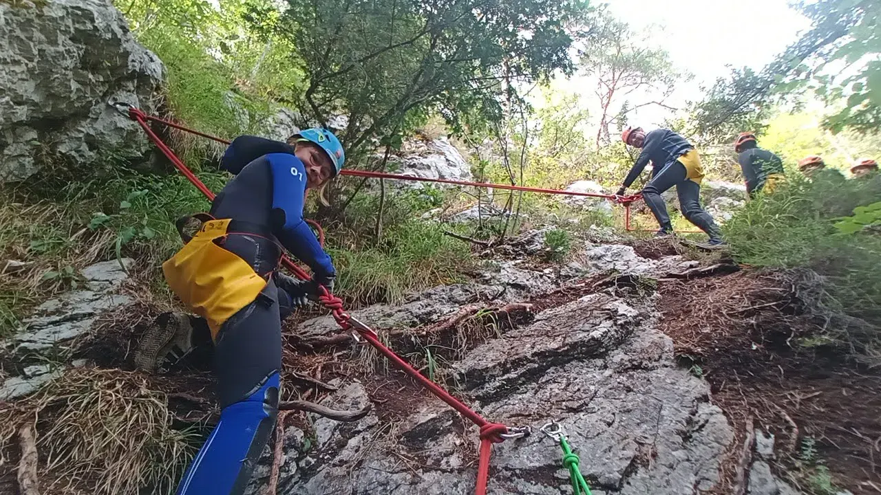 Zwei Canyonaut:innen bei einem Klettersteig-Abschnitt.