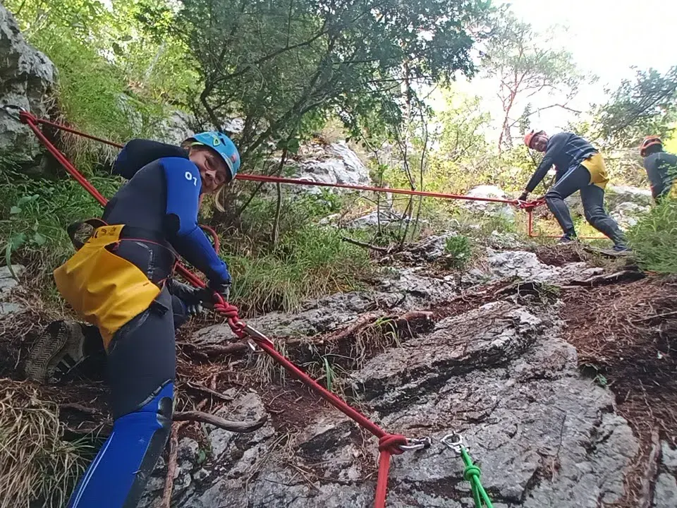 Zwei Canyonaut:innen bei einem Klettersteig-Abschnitt.