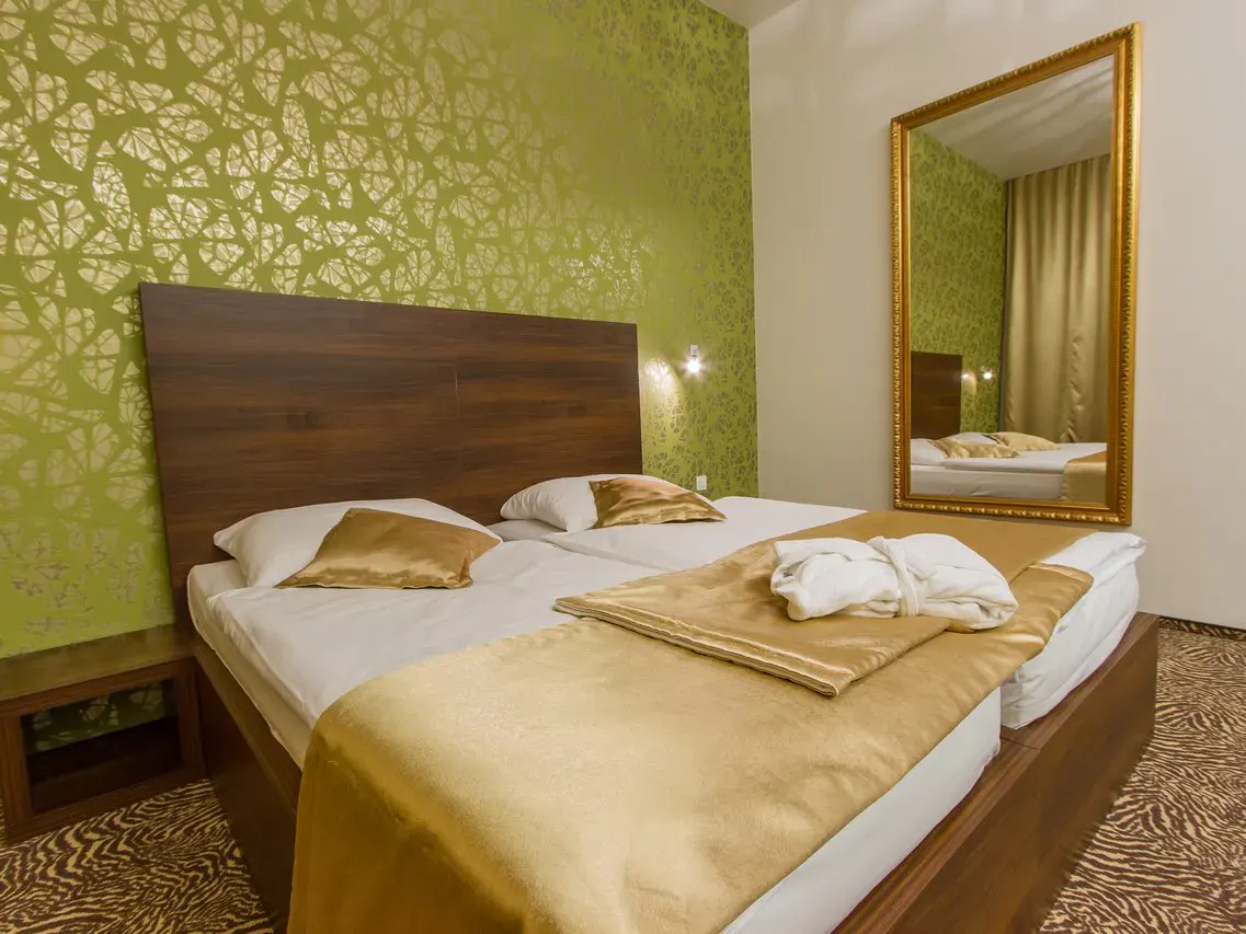 Doppelzimmer mit goldenen Akzenten und hellgrüner Tapete im Rimske Terme Hotel Rimski dvor