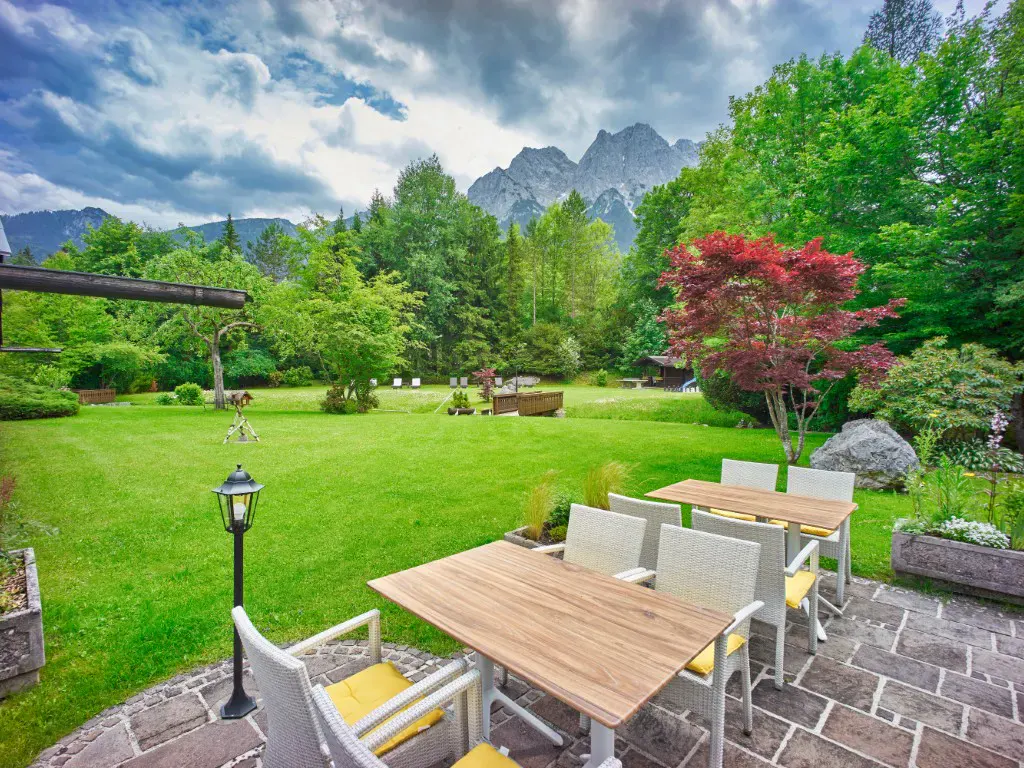 Blick auf die Terrasse und den Garten im Alpenhof Grainau