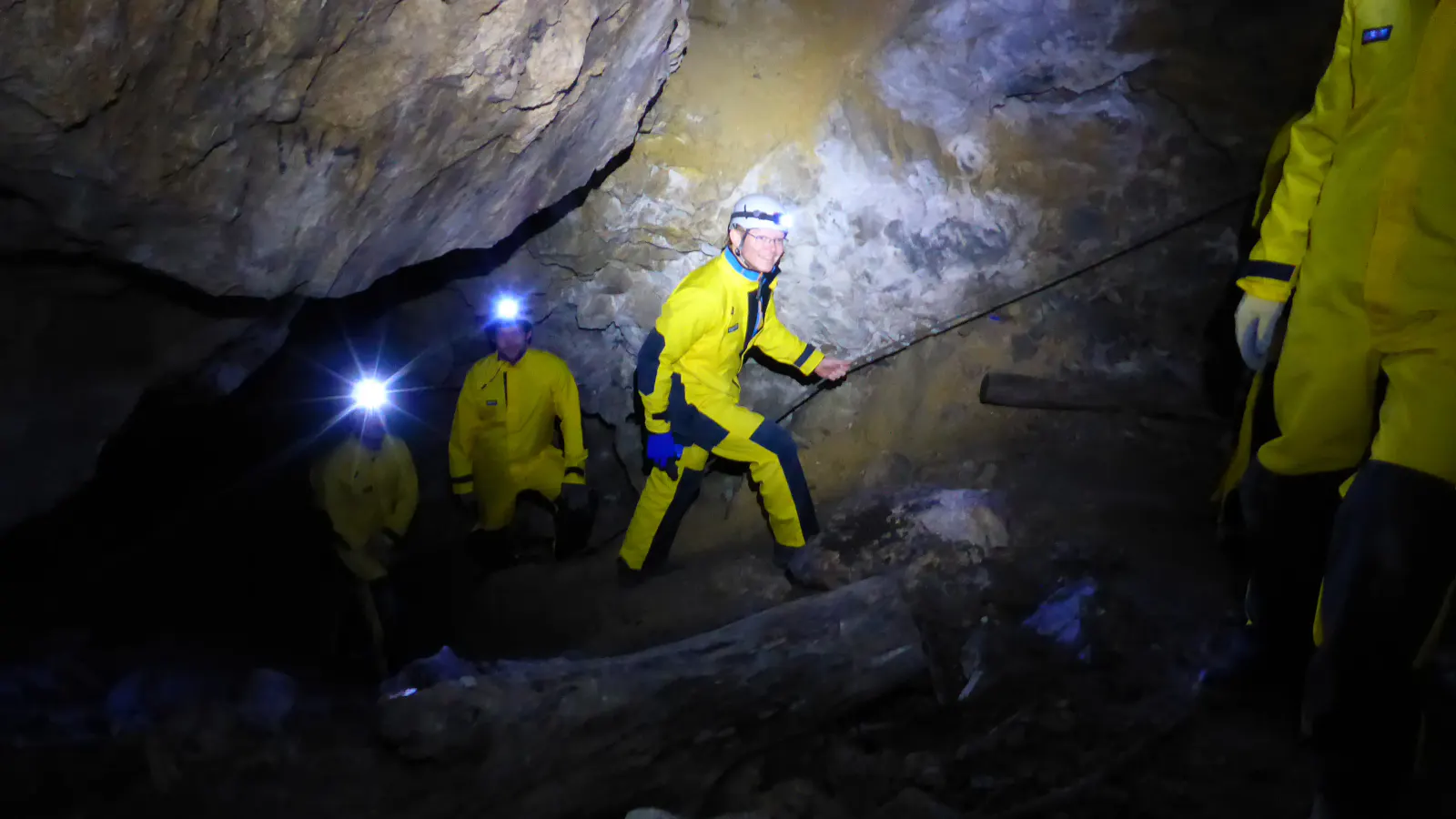 Personen gehen an einem Seil entlang durch die Höhle.