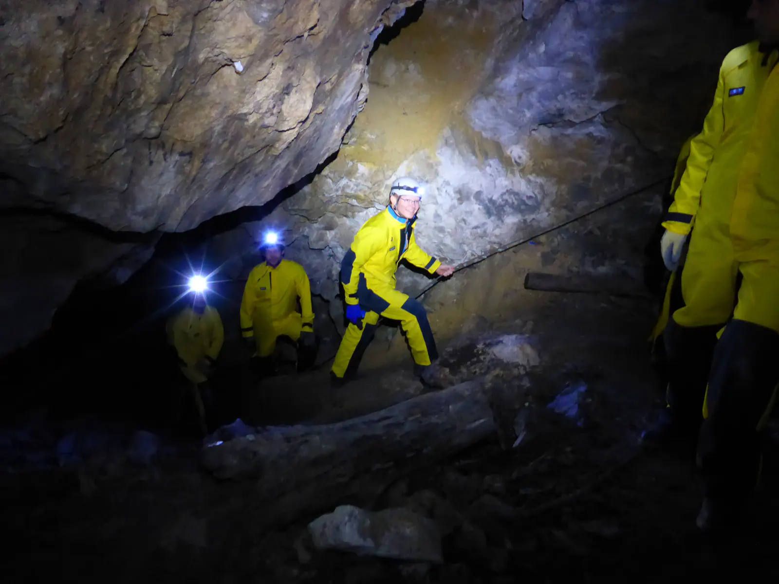 Personen gehen an einem Seil entlang durch die Höhle.