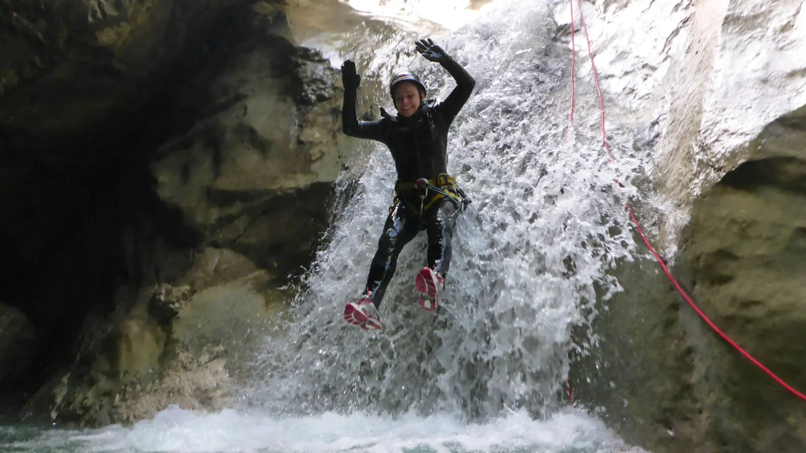 Eine Person rutscht einen Wasserfall hinunter.