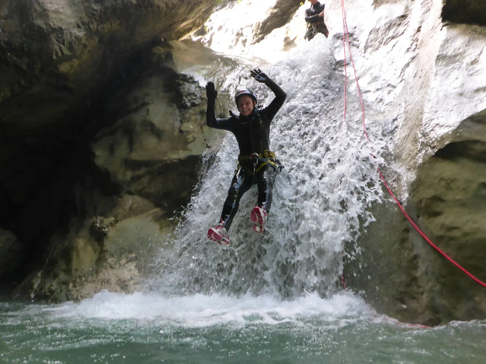Eine Person rutscht einen Wasserfall hinunter.