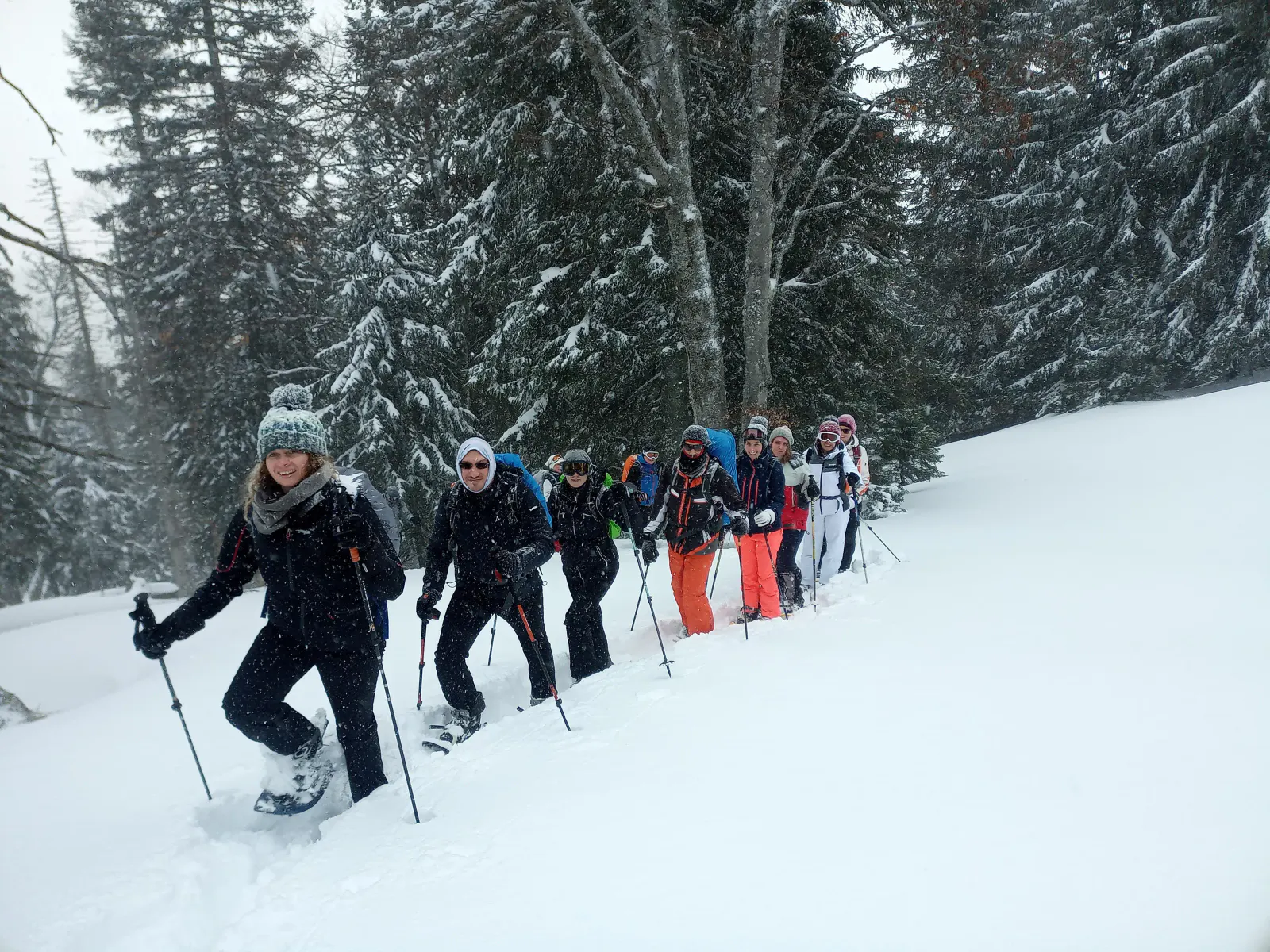 Eine Gruppe beim Schneeschuhwandern während es schneit