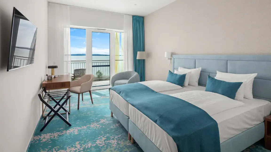 Doppelzimmer mit türkisem Dekor und Blick auf den Plattensee im Hotel Sirius