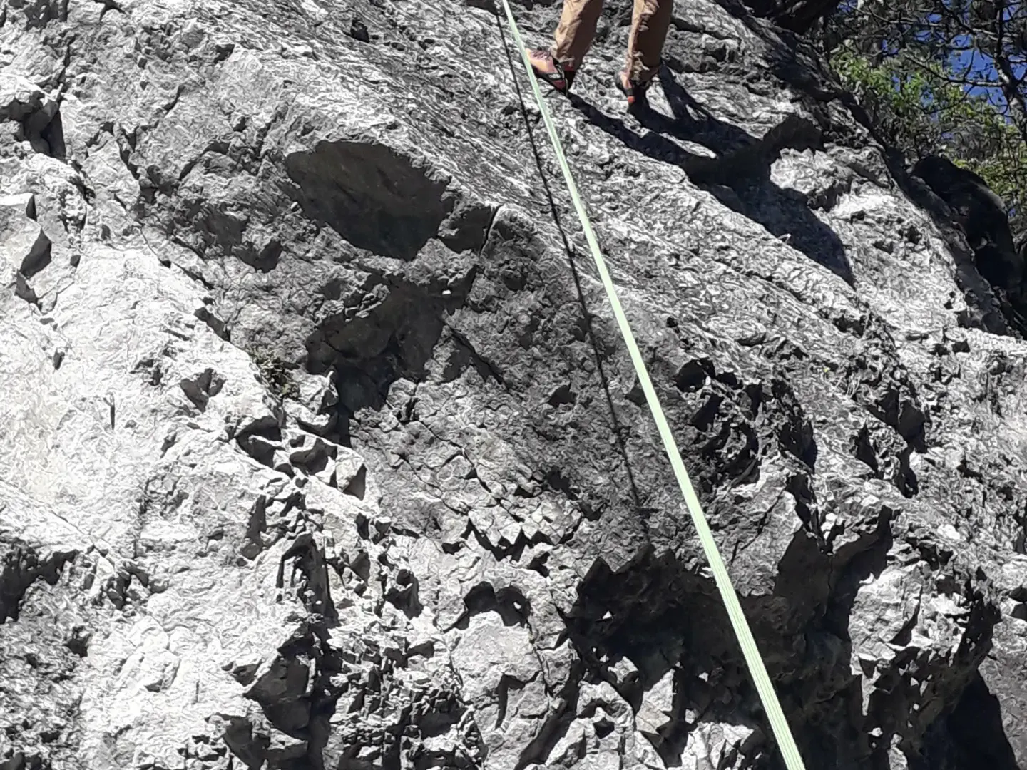 Eine Person ist sehr weit oben in der Felswand.