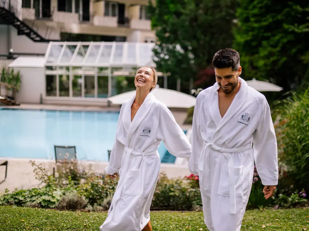 Ein Paar im Bademantel im Garten des Hotels Warmbaderhof