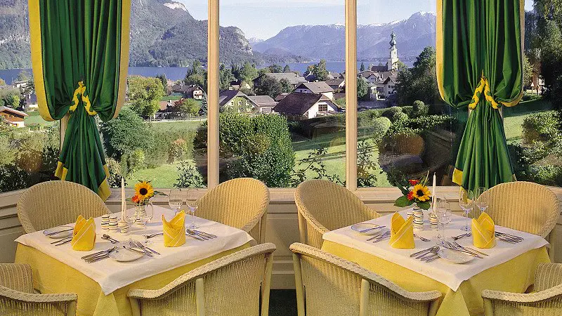 Blick auf einen gedeckten Tisch mit Aussicht auf den Wolfgangsee vom Hotel Hollweger Wintergarten aus