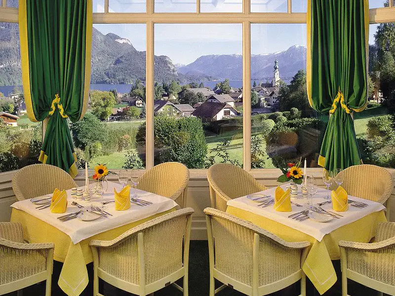 Blick auf einen gedeckten Tisch mit Aussicht auf den Wolfgangsee vom Hotel Hollweger Wintergarten aus