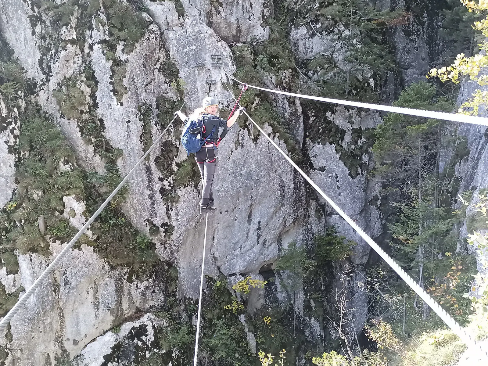 Eine Person balanciert auf einem Seil über eine Schlucht.