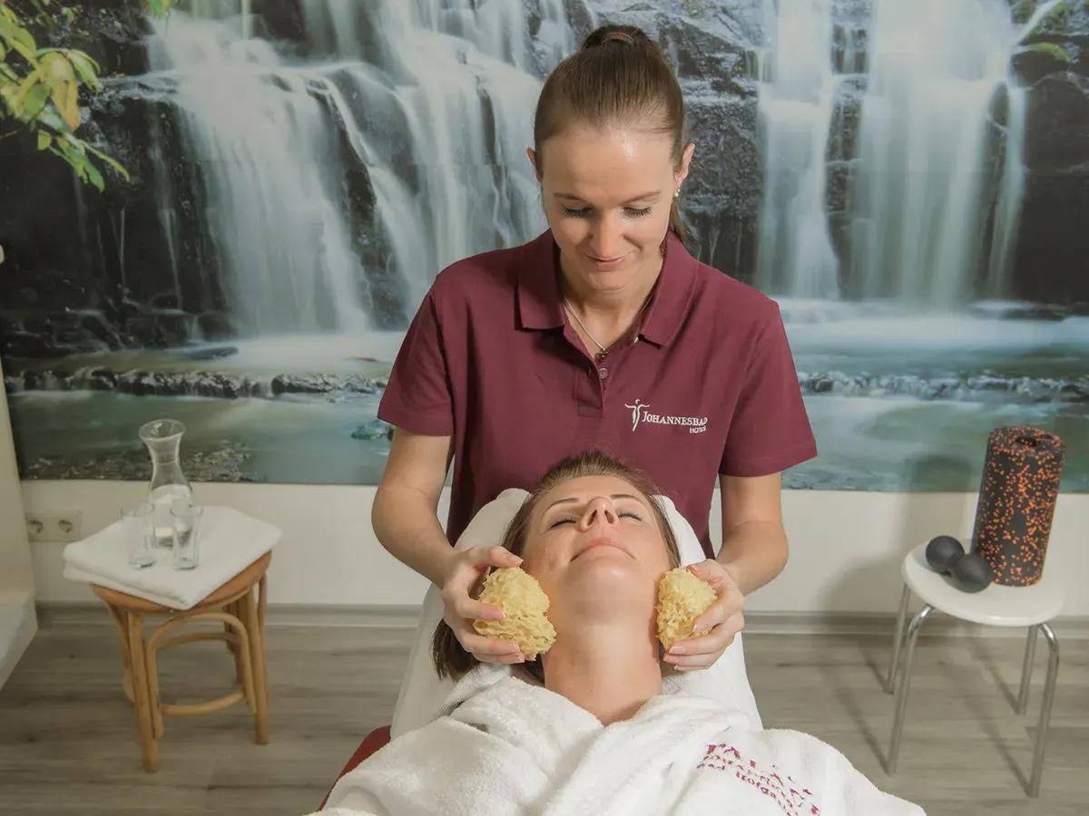 Eine Dame genießt eine Behandlung durch eine Therapeutin im Hotel Palace