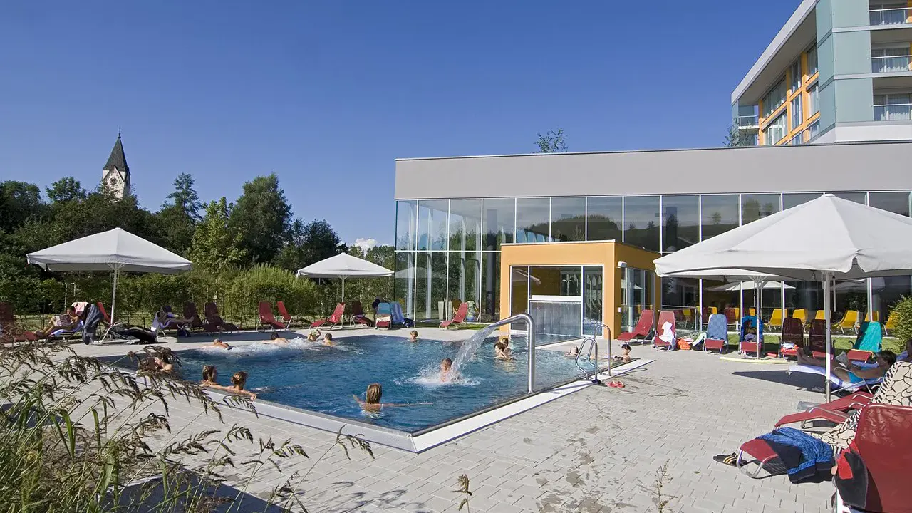 Blick auf den Aussenpool und die Kirche im Hintergrund des Gesundheitsresorts Lebensquell Bad Zell