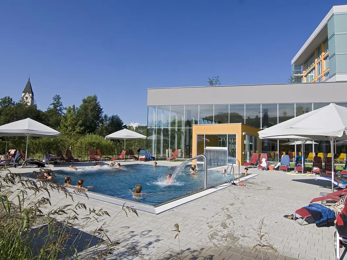Blick auf den Aussenpool und die Kirche im Hintergrund des Gesundheitsresorts Lebensquell Bad Zell