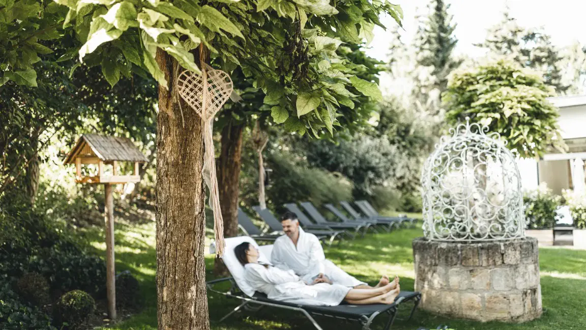 ein paar genießt die Ruhe im Garten des Kuschelhotels Loipersdorf