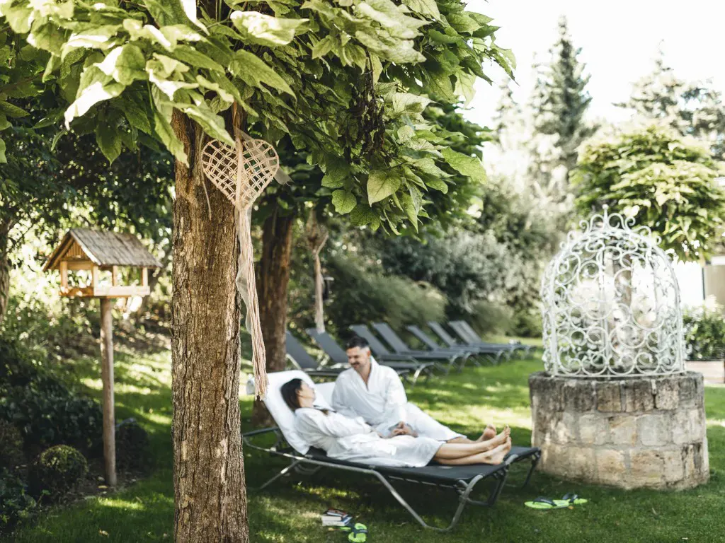 ein paar genießt die Ruhe im Garten des Kuschelhotels Loipersdorf