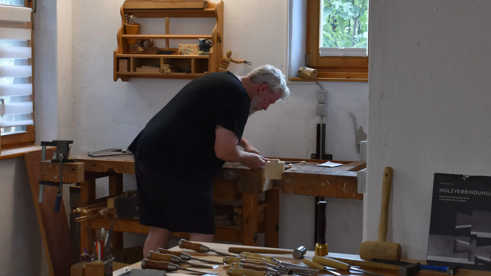 Kursteilnehmer beim Arbeiten mit Werkzeugbuffet im Vordergrund
