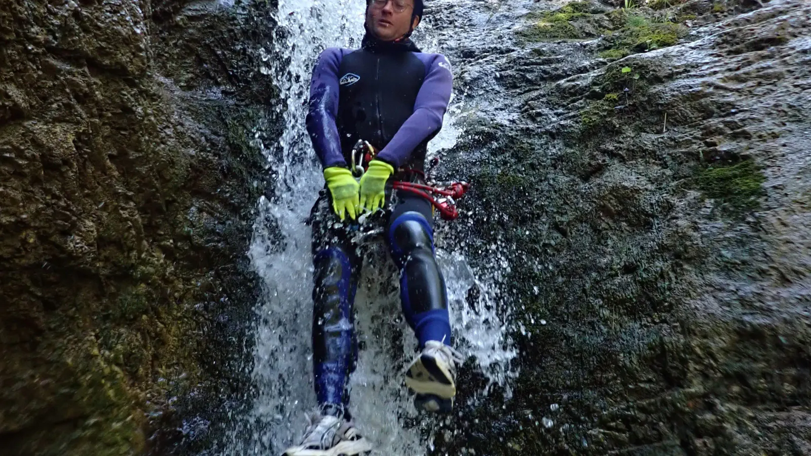 Eine Person rutscht einen kleinen Wasserfall hinunter.