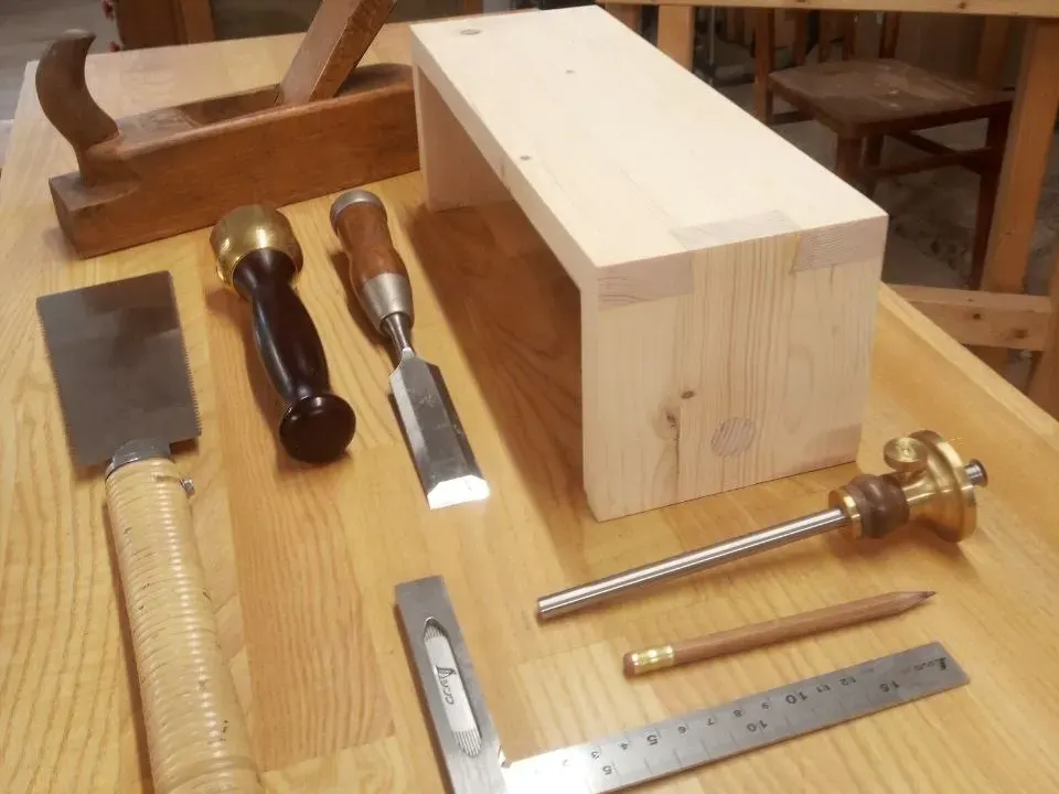 Einfaches Werkstück mit klassischen Holzverbindungen und Handwerkzeugen