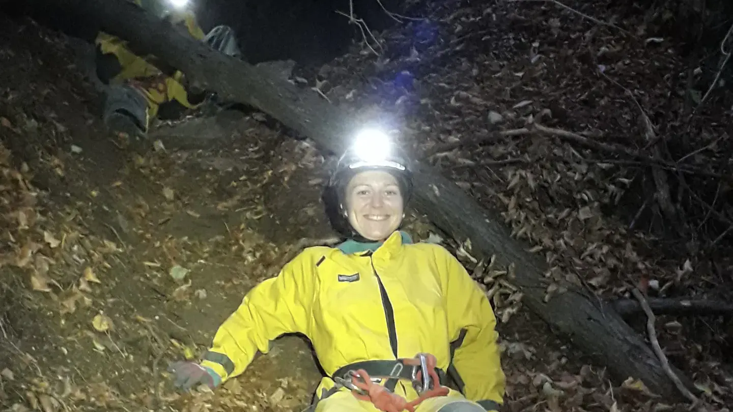 Eine Person in Höhlenanzug beim Zustieg zur Höhle.