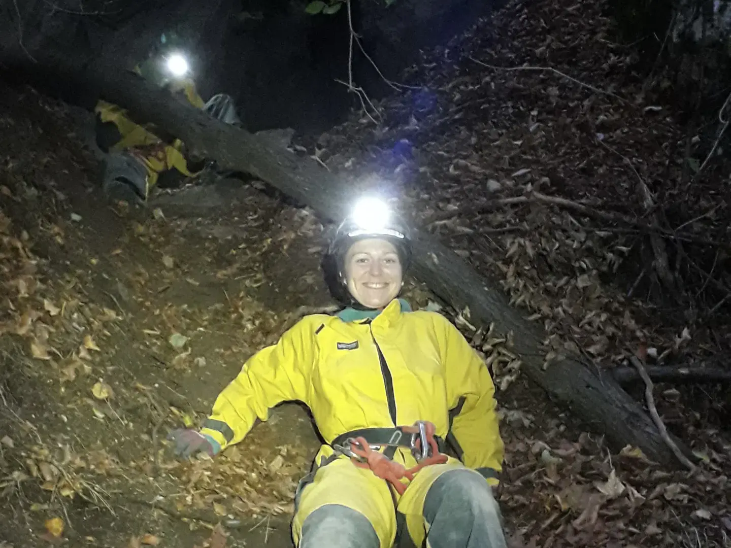 Eine Person in Höhlenanzug beim Zustieg zur Höhle.