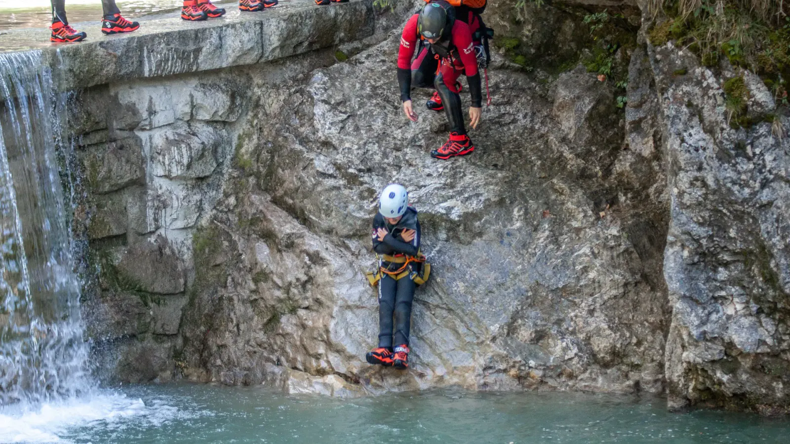 Kind rutscht über Stein in Bach wie bei natürlichem Wasserpark