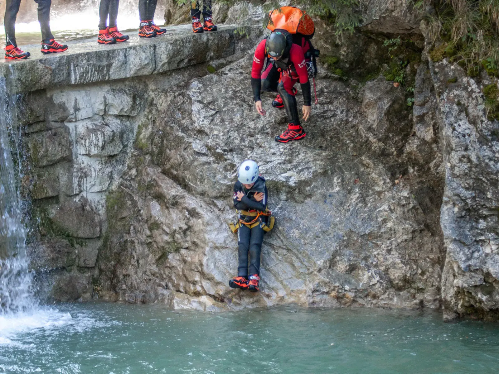 Kind rutscht über Stein in Bach wie bei natürlichem Wasserpark