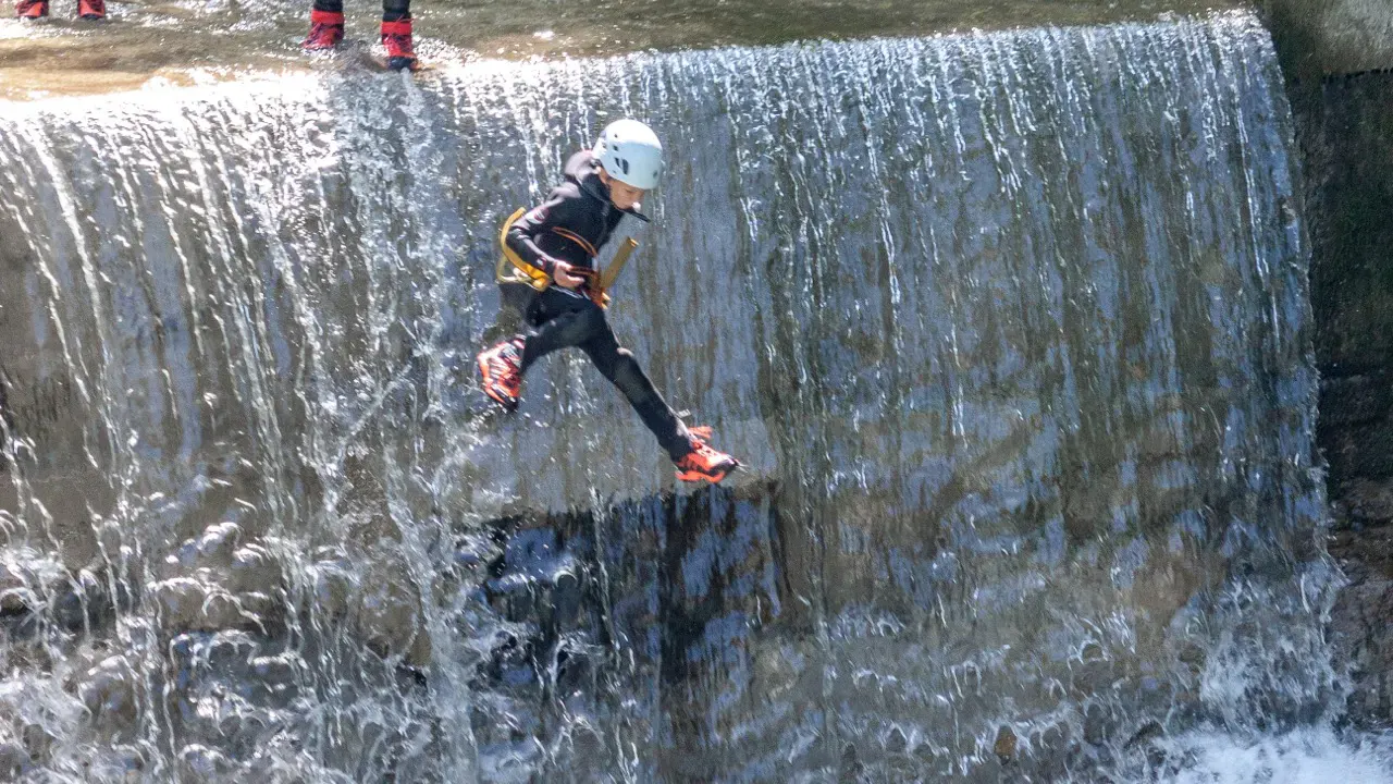 Kind springt kleinen Wasserfall runter