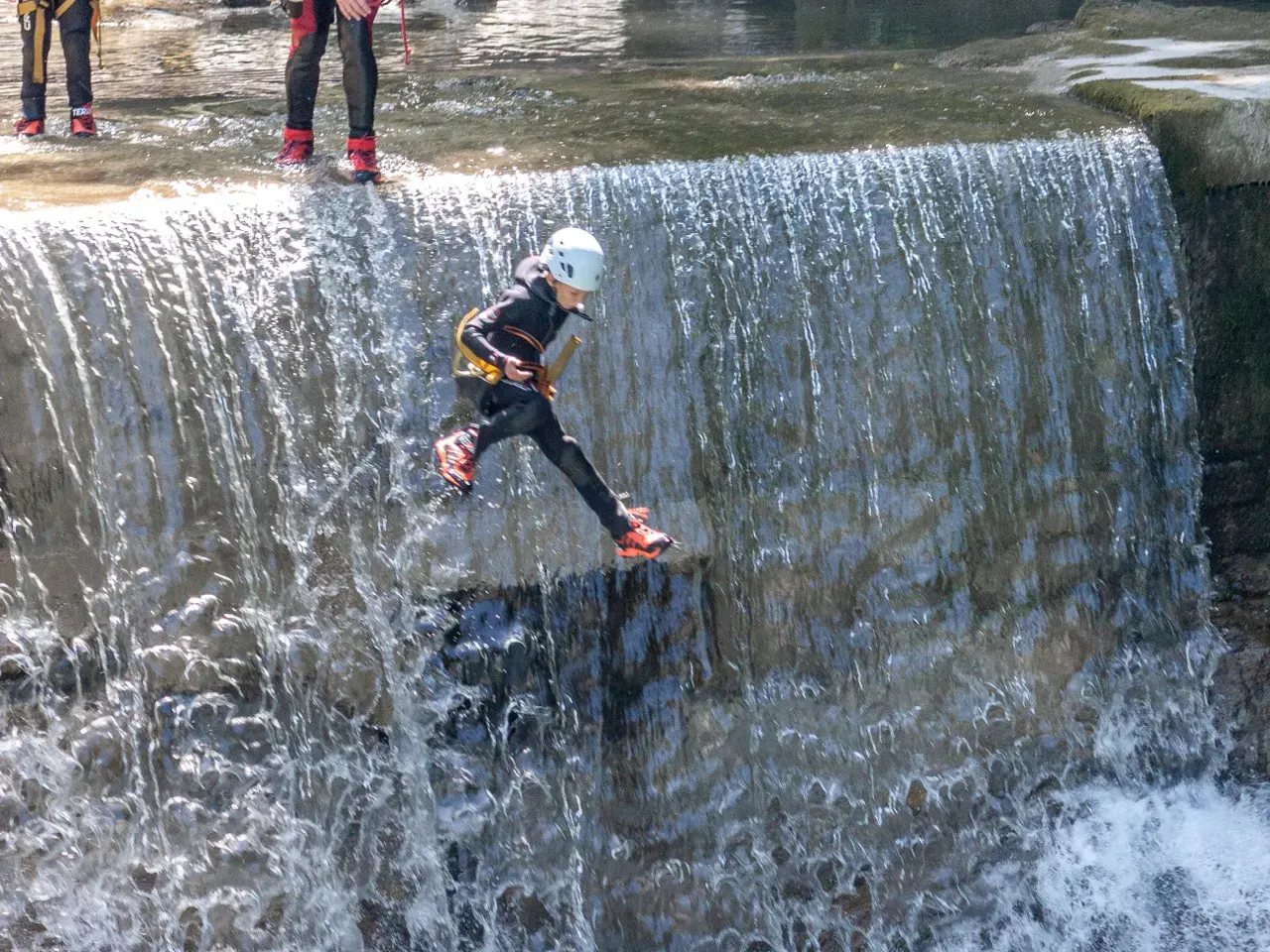 Kind springt kleinen Wasserfall runter